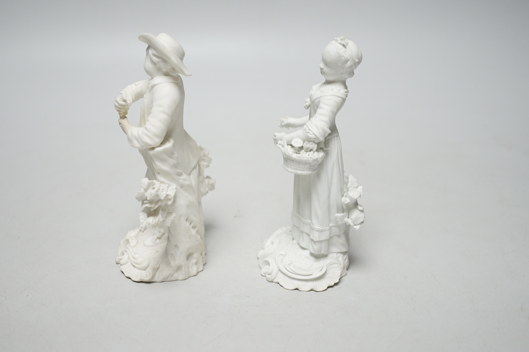 A pair of 18th century Derby biscuit figures of a man and woman, he with a bunch of grapes and she with a basket of flowers possibly representing Spring and Autumn, pattern number 125